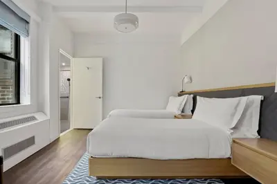 a bedroom with a large white bed and a window at Newly Renovated Rooms at Club Quarters Hotel Times Square, New York in New York