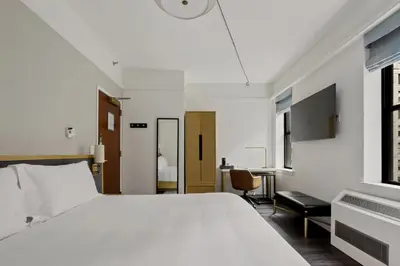 a bedroom with a white bed and a desk at Newly Renovated Rooms at Club Quarters Hotel Times Square, New York in New York