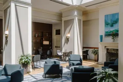 a lobby with blue chairs and a fireplace at Club Quarters Hotel Rittenhouse Square, Philadelphia in Philadelphia