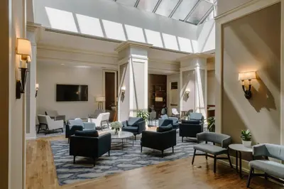 a lobby with chairs and tables and a skylight at Club Quarters Hotel Rittenhouse Square, Philadelphia in Philadelphia