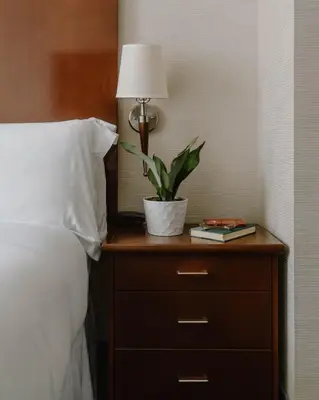 a plant on a night stand next to a bed at Club Quarters Hotel Rittenhouse Square, Philadelphia in Philadelphia