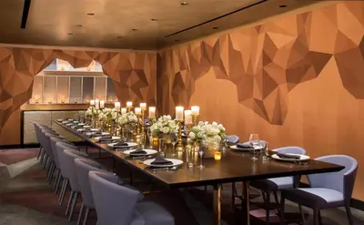 a long table in a room with chairs and candles at The Time New York, part of JdV by Hyatt in New York