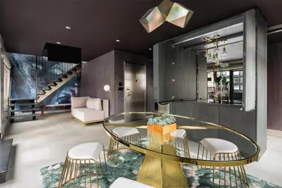 a living room with a glass table and chairs at The Time New York, part of JdV by Hyatt in New York