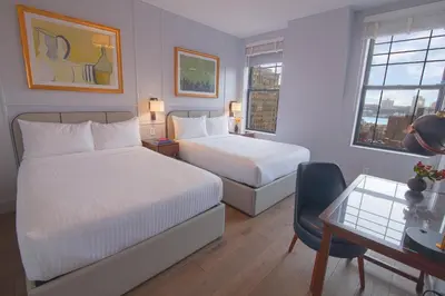 a hotel room with two beds and a desk and a chair at Hotel Belleclaire Central Park in New York