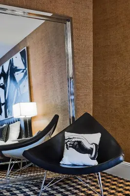 a room with two black chairs and a mirror at Ameritania at Times Square in New York