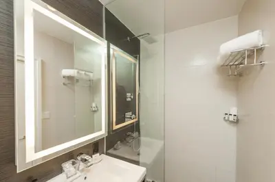a bathroom with a sink and a mirror at Ameritania at Times Square in New York