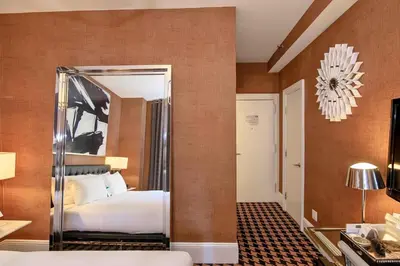 a bedroom with a bed and a mirror at Ameritania at Times Square in New York