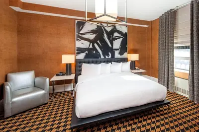 a bedroom with a white bed and a chair at Ameritania at Times Square in New York