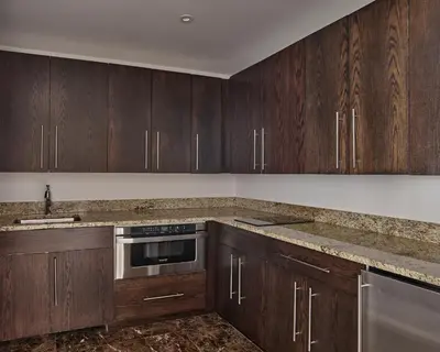 a kitchen with wooden cabinets and stainless steel appliances at AKA Central Park in New York
