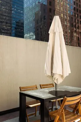 a white umbrella sitting on top of a table with chairs at The Bayard in New York