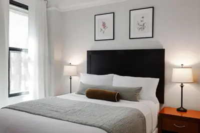 a bedroom with a large white bed with two lamps at The Bayard in New York
