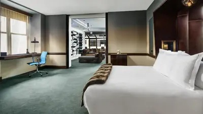 a hotel room with a large bed and a chair at Royalton New York in New York