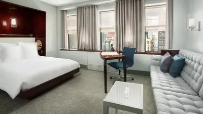 a hotel room with a bed and a couch at Royalton New York in New York