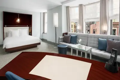 a hotel room with a bed and a couch at Royalton New York in New York