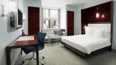 a bedroom with a bed and a desk and a chair at Royalton New York in New York
