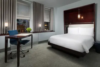 a hotel room with a bed and a desk and a chair at Royalton New York in New York