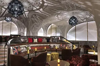 a dining room with tables and chairs and chandeliers at Bryant Park Hotel in New York