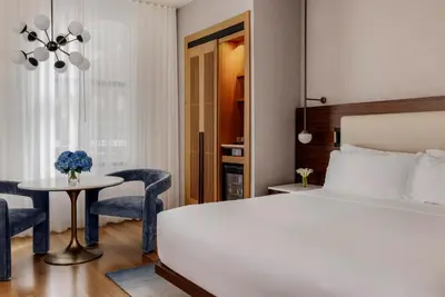 a bedroom with a bed and a table and chairs at Bryant Park Hotel in New York