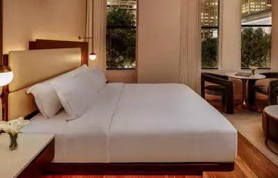 a bedroom with a large white bed and a table at Bryant Park Hotel in New York