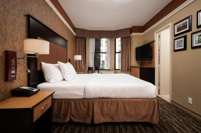 a hotel room with a large bed and a television at The Hotel at Fifth Avenue in New York