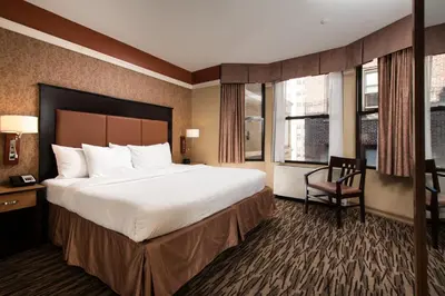 a hotel room with a large bed and a chair at The Hotel at Fifth Avenue in New York