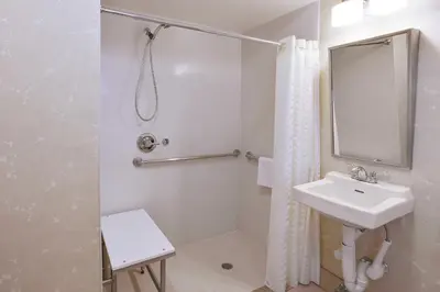 a white bathroom with a sink and a mirror at The Hotel at Fifth Avenue in New York