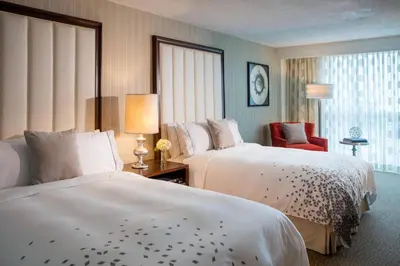 a hotel room with two beds and a chair at Renaissance Newark Airport Hotel in Elizabeth