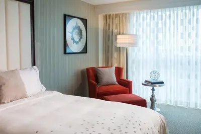 a bedroom with a bed and a chair and a window at Renaissance Newark Airport Hotel in Elizabeth