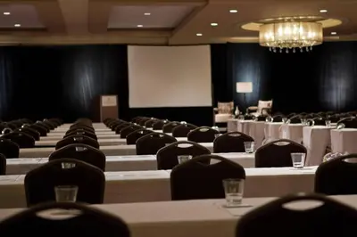 a conference room with tables and chairs and a screen at Renaissance Newark Airport Hotel in Elizabeth