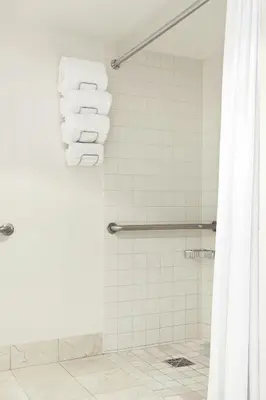 a bathroom with a shower with white towels at Renaissance Newark Airport Hotel in Elizabeth