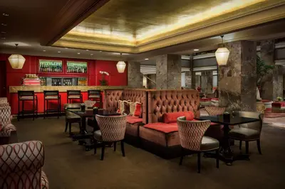 a restaurant with a couch and tables and a bar at The Michelangelo New York in New York