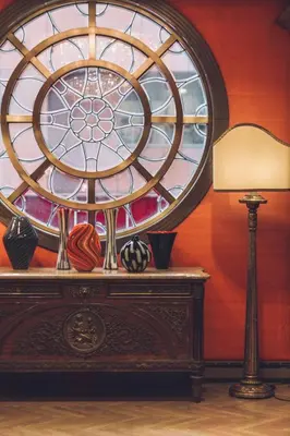 a table with a lamp and a stained glass window at The Michelangelo New York in New York