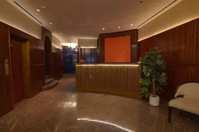 a lobby with a waiting area with a potted plant at Iroquois New York Times Square in New York