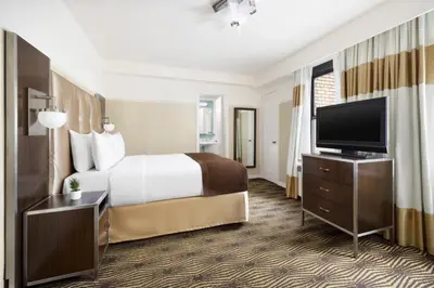 a hotel room with a bed and a flat screen tv at New Yorker by Lotte Hotels in New York