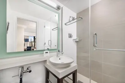 a white bathroom with a sink and a mirror at New Yorker by Lotte Hotels in New York