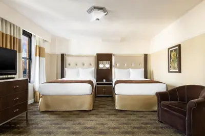 a hotel room with two beds and a television at New Yorker by Lotte Hotels in New York