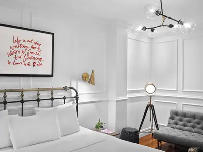 a bedroom with white walls and a bed and a chair at Life Hotel New York in New York