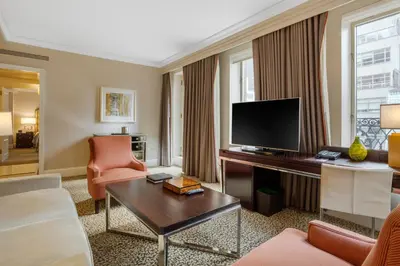 a living room with a couch and a television at Omni Berkshire Place in New York