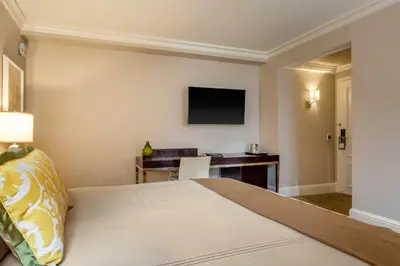 a hotel room with a bed and a desk at Omni Berkshire Place in New York