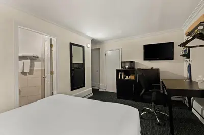 a hotel room with a white bed and a desk at Quality Inn Philadelphia Center City in Philadelphia