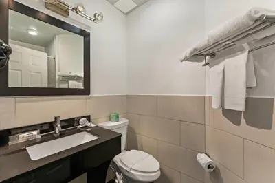 a bathroom with a sink and a toilet and a mirror at Quality Inn Philadelphia Center City in Philadelphia