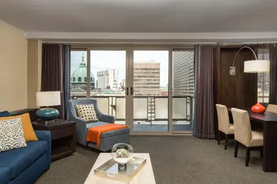 a living room with a blue couch and a view of a city at The Windsor Suites in Philadelphia