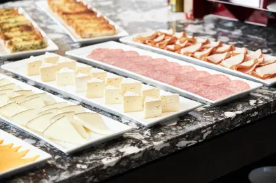 a buffet of different types of cheese and meats at AC Hotel by Marriott Bridgewater in Bridgewater