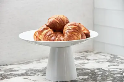 a white plate with two croissants on it at AC Hotel by Marriott Bridgewater in Bridgewater