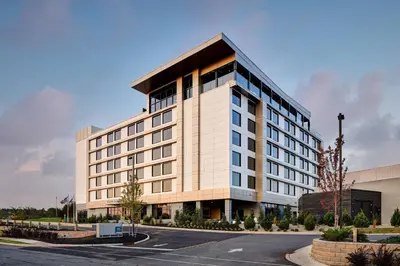 a large white building with a parking lot at AC Hotel by Marriott Bridgewater in Bridgewater