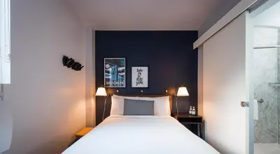a bedroom with a bed and a blue wall at U Hotel Fifth Avenue, Empire State Building in New York