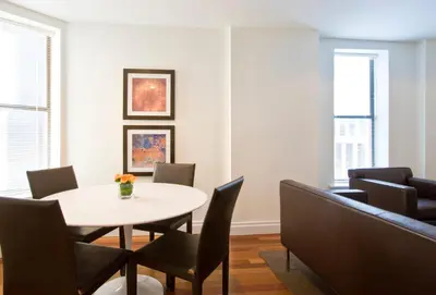 a dining room with a white table and chairs at AKA Times Square in New York