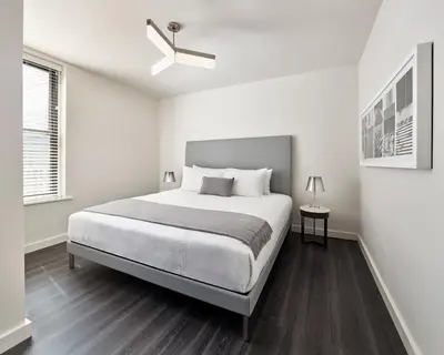 a white bedroom with a bed and a ceiling fan at AKA Times Square in New York
