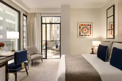 a hotel room with a bed and a desk and chair at The Chemists Club Hotel in New York