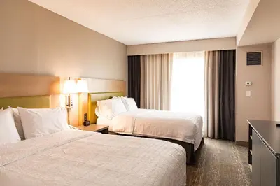 a hotel room with two beds and a window at Hampton Inn & Suites By Hilton- Newark Airport Elizabeth in Newark